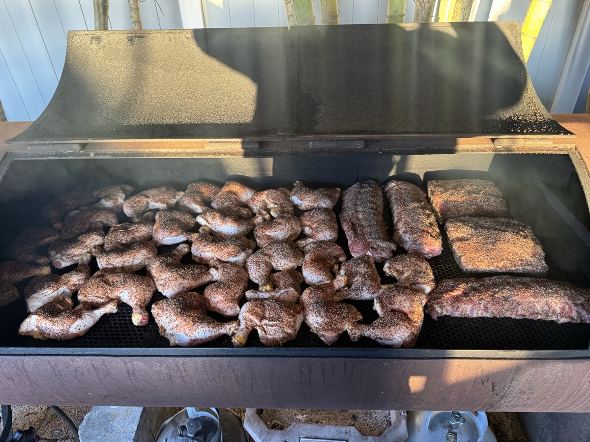Smoker loaded with chicken, ribs, and brisket for a catering event